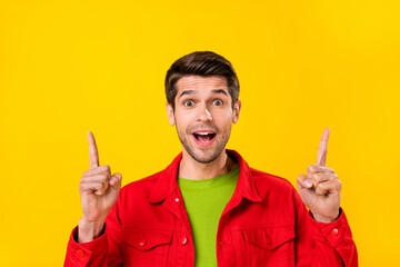 Portrait of attractive cheerful amazed guy pointing forefingers up copy space ad isolated over...