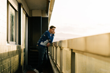 Man contemplating the city from a balcony