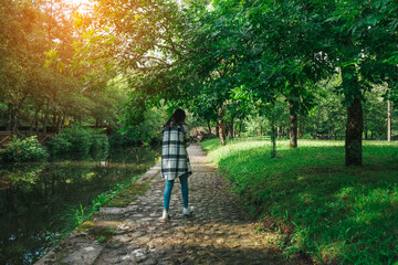 Fototapeta premium Young woman walking by a path along the river
