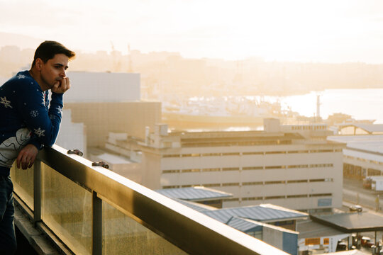 Man contemplating the city from a balcony