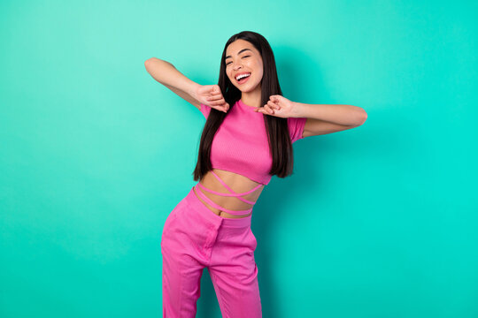Photo of adorable female in trendy set of clothes feel free dancing in club isolated on teal color background