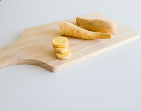 baroa potatoes over wooden table on white background