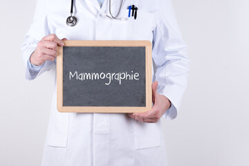 Arzt mit einer Tafel auf der Mammographie steht