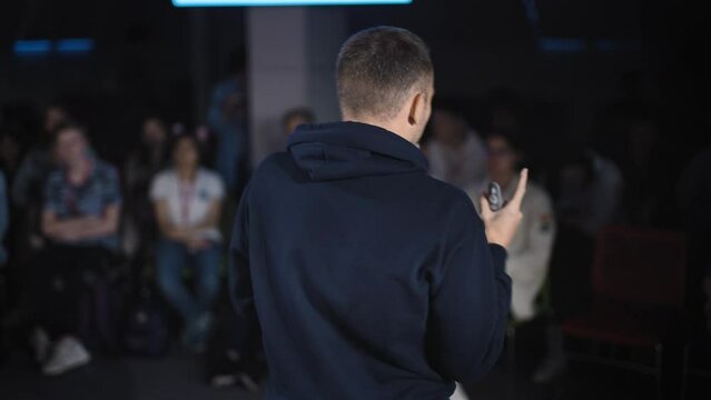 Conference in the IT industry. A young and successful male speaker talks about modern solutions to students and colleagues.