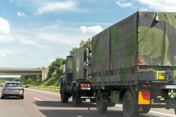 Obraz premium German armoured semi-trailer cargo truck carrier drives military convoy highway road. NATO troops moving reloceation rapid reaction force reinforcement eastern Europe . Sweden Finland fortification