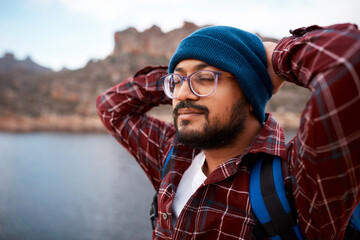 A hiking man takes a break and meditates while backpacking through the mountains