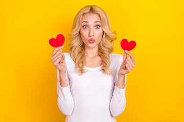 Photo of shiny funny lady dressed white shirt rising two small hearts lips pouted isolated yellow color background