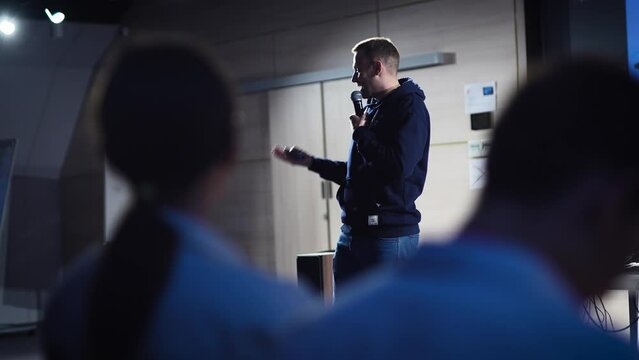 Conference in the IT industry. A young and successful male speaker talks about modern solutions to students and colleagues.