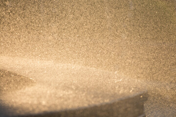 Drops of water splatter fly with yellow golden rays of the sun at sunset concept of freshness drink, watering the rain source of clean water fountain, copy space