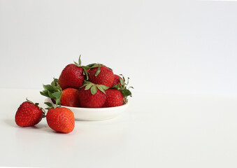 Bright close up photo of a delicious strawberry in a white bowl. healthy food