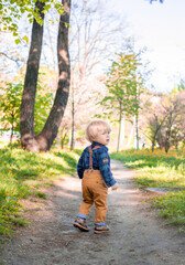 Style baby boy walking in the park 