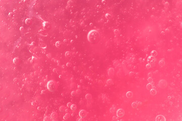 Texture of transparent pink gel with air bubbles and waves on white background. Concept of skin...