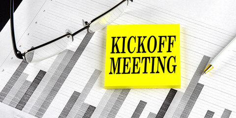 Word KICKOFF MEETING on a yellow sticky on the chart background