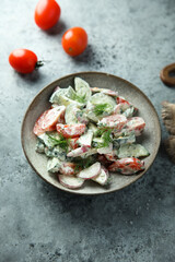Homemade vegetable salad with tomato, cucumber and sour cream