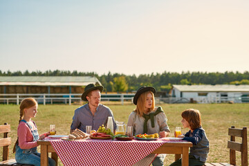 Young caucasian farm family having lunch outdoors