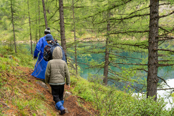 Family hiking in the woods near turquoise lake