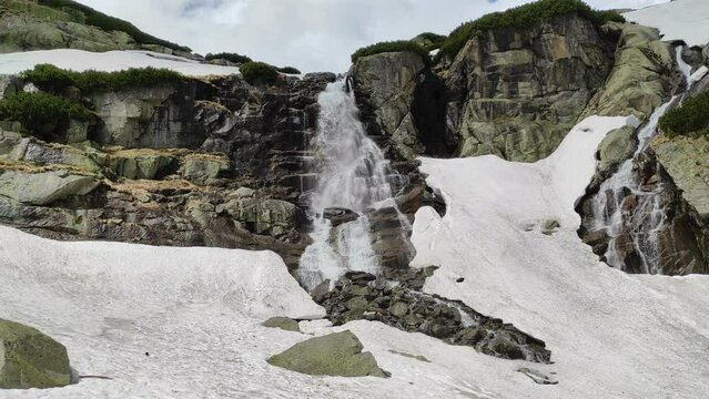 Waterfall jump in High Tatras in spring with remnants of snow. Hiking trail 1:35 from Strbske pleso. 