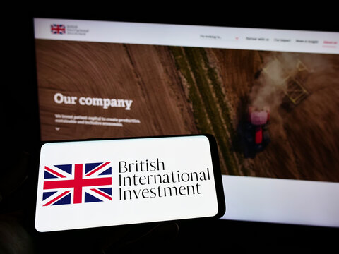 Stuttgart, Germany - 06-25-2022: Person holding smartphone with logo of British International Investment (BII) on screen in front of website. Focus on phone display.