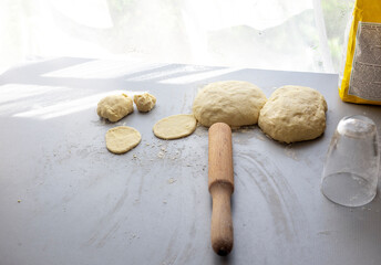 Grandma rolls out py dough on the table with a rolling pin
