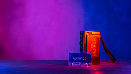 Vintage cassette tape player in neon light. 80s - 90s advertisement style. Disco party nostalgy concept - 513949934