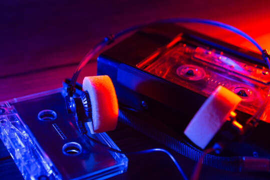 Vintage cassette tape player in neon light. 80s - 90s advertisement style. Disco party nostalgy concept