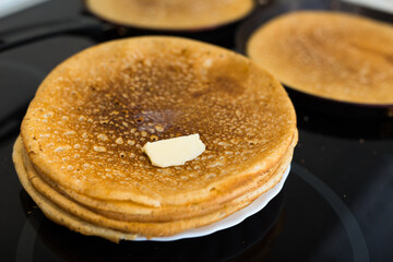 stack of appetizing flour pancakes in the kitchen during cooking