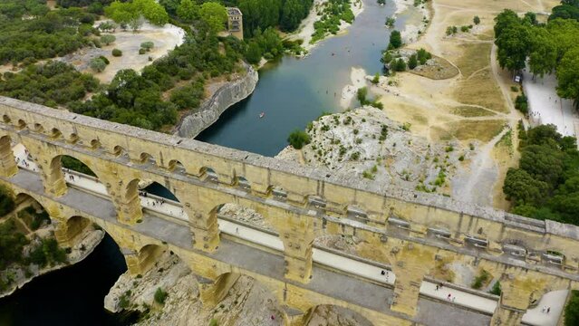 aerial of Pont du Gard is an ancient Roman aqueduct that crosses the Gardon River. The Pont du Gard is an ancient Roman aqueduct bridge built in the first century. 