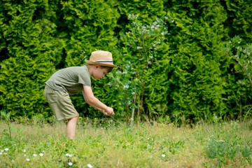 Naklejka na ściany i meble Little autist preschool boy in hat play in garden