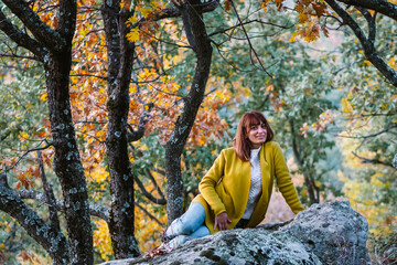 young woman enjoying an idyllic landscape wearing a yellow jacket