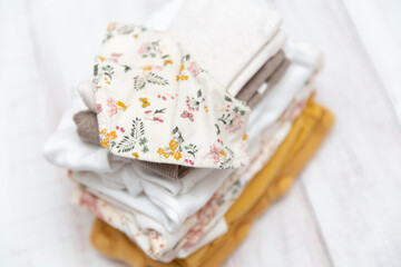 White and yellow baby clothes folded
