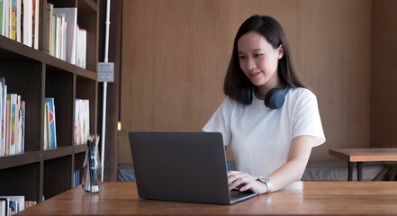 Smart asian young girl student feel satisfied during internet online courses and searching information via laptop computer at home