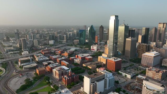 Downtown Dallas Texas skyline. Aerial pan at magic golden hour light. Sunset over Trinity River bridges in TX USA.