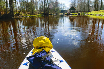 view from paddle board to wild river on a sunny spring day, active holidays outdoors