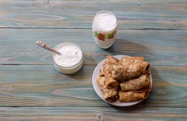Still life with kefir, sour cream and delicious pancakes with meat