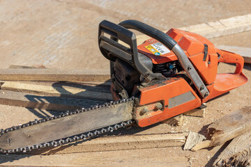 Chainsaw at the construction site. Reliable mobile tool for cutting boards and wooden blocks.