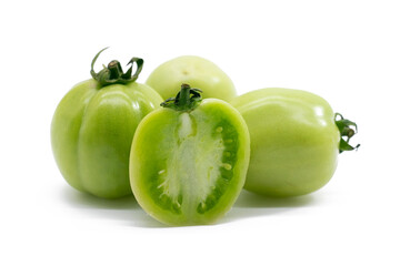 Whole and halved green unripe tomatoes isolated on white background