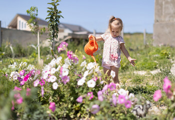 Baby  watering the flowers with a watering can