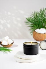 Obraz na płótnie Canvas Coconut wax candle in a black jar on a white background. natural eco friendly coconut wax candles. Trendy concept. minimalist. isometric projection. copy space.
