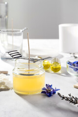 Set tools for homemade natural eco-friendly soy wax candles, wick, perfume, essential oil on a marble table. Making process. Trendy DIY. Craft hobby, small business, artisan products concept