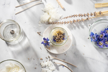 Set tools for homemade natural eco-friendly soy wax candles, wick, perfume, essential oil on a marble table. Making process. Trendy DIY. Craft hobby, small business, artisan products concept