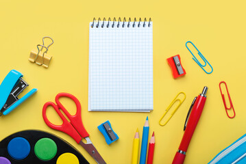 Top view of blank spiral notepad and school supplies with space for text. Back to school concept