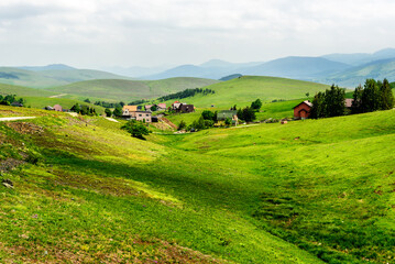 Mountain Village on a Sunny Summer day, with green hills and meadows