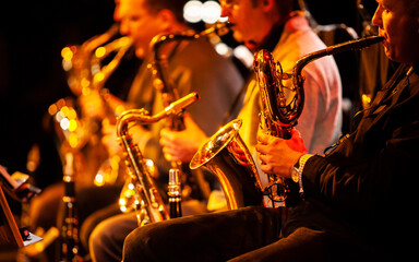Big Band: the sax section. Focus on the foreground baritone saxophone. From a series of images of...