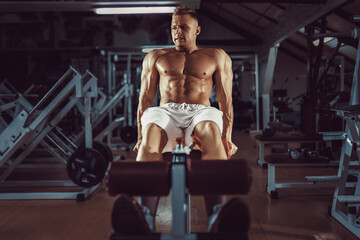 Obraz premium Muscular man exercising doing sit up exercise. Athlete with six pack, white male, no shirt
