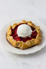 Mini biscuit with strawberries and a ball of ice cream. Delicious berry pie on a white background