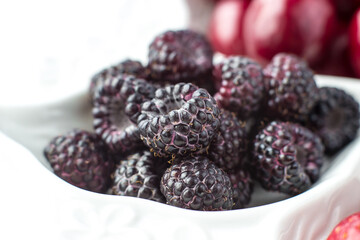 Close-up of raspberries on a fruit plate on a white background. Ripe berries. Vitamins and a healthy lifestyle