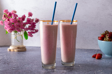 Fresh delicious milk strawberry smoothies in glass glasses and berries on the table. Summer drink concept
