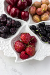 Berry plate on a white background. Strawberries, gooseberries, cherries, raspberries and mulberries