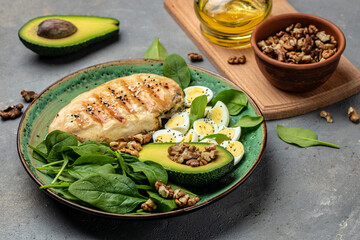 ingredients for a ketogenic diet avocado, grilled chicken fillet, quail egg, spinach, walnut. Healthy fats, clean eating for weight loss, Food recipe background. Close up, top view