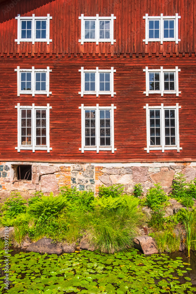 Canvas Prints Old red wooden building with windows by a stream